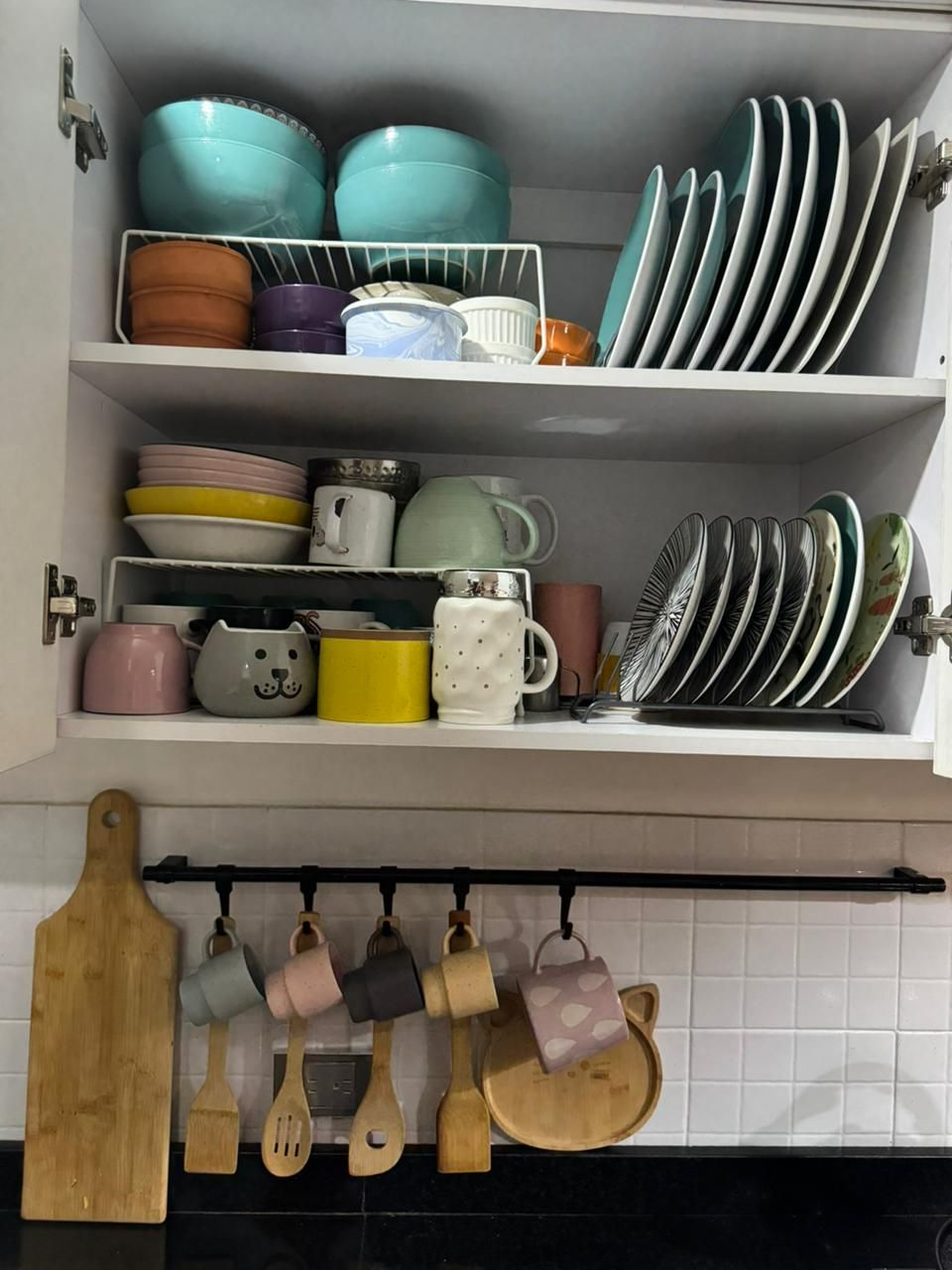 A few simple plates and bowls neatly stacked inside a small kitchen cabinet.