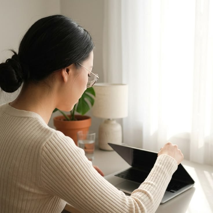 A person closing a laptop at home with a relaxed, peaceful setting as regards to how to build healthy work habits