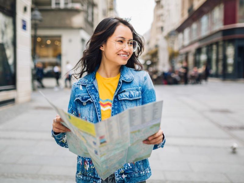 A person looking at a neighbourhood map while taking a walk on the streets. 
