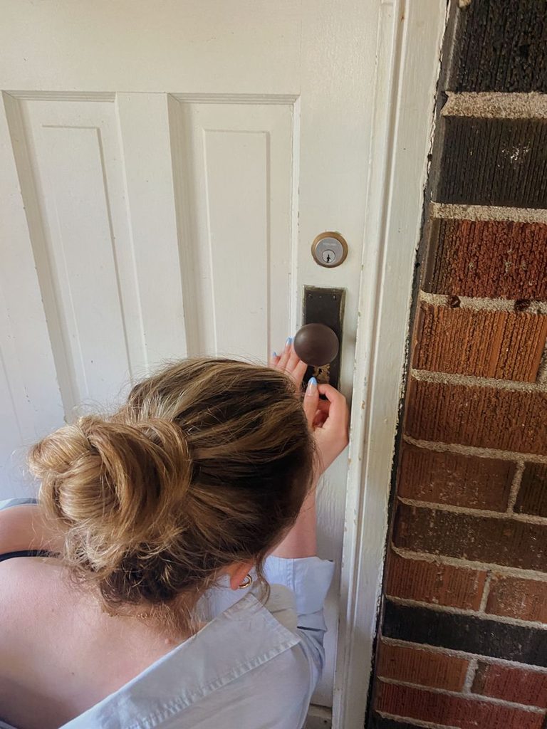 A young adult checking and locking their apartment door before leaving home  as regards to how to manage the responsibilities of living on your own