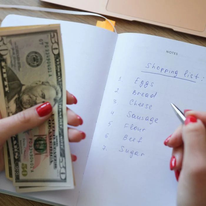 Someone checking their budget before going shopping as regards to how to prepare for your first grocery shopping trip