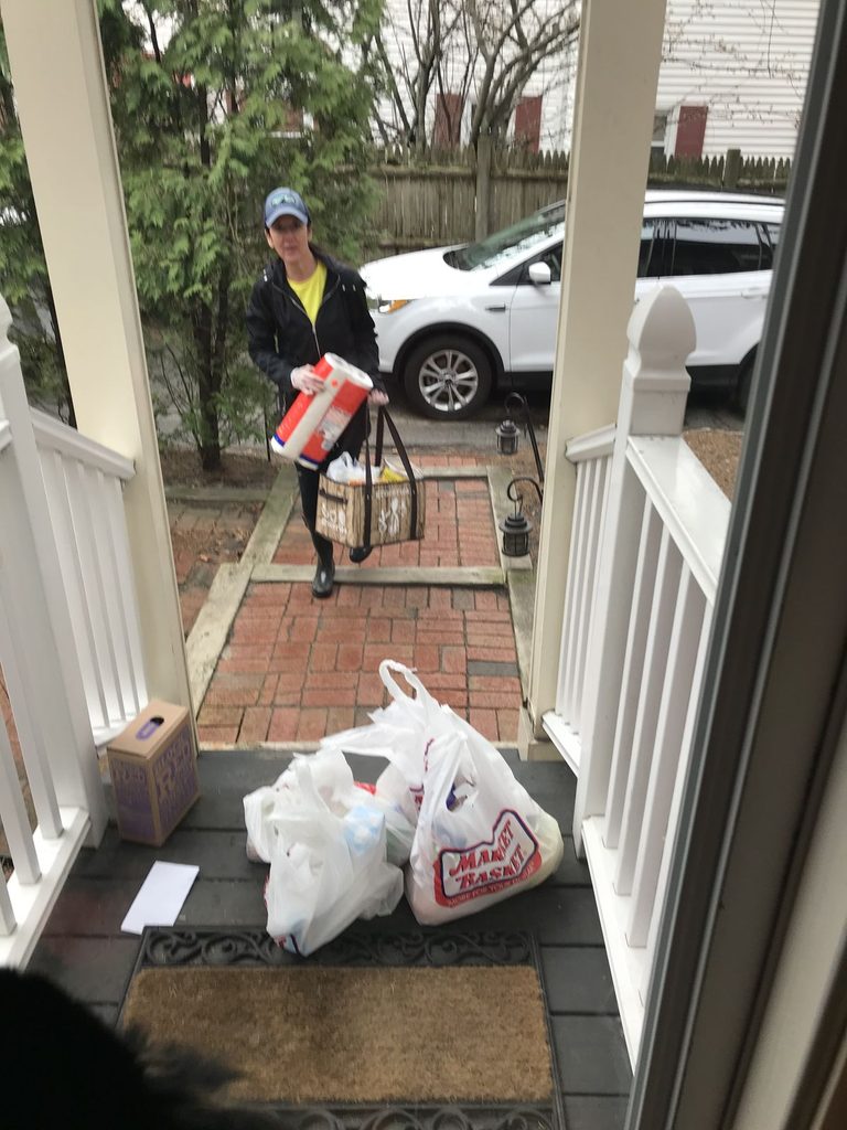 A young adult organizing letters and packages near the entrance of a new apartment.