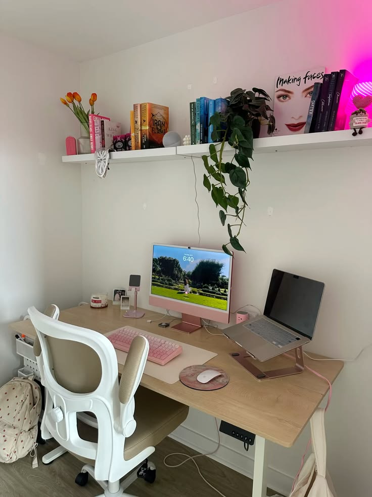 A young adult setting up a laptop, desk, and charger area in a simple apartment.