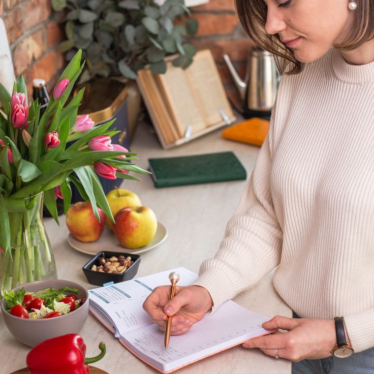 lady writing a grocery list on the kitchen counter as regards to how to prepare for your first grocery shopping trip